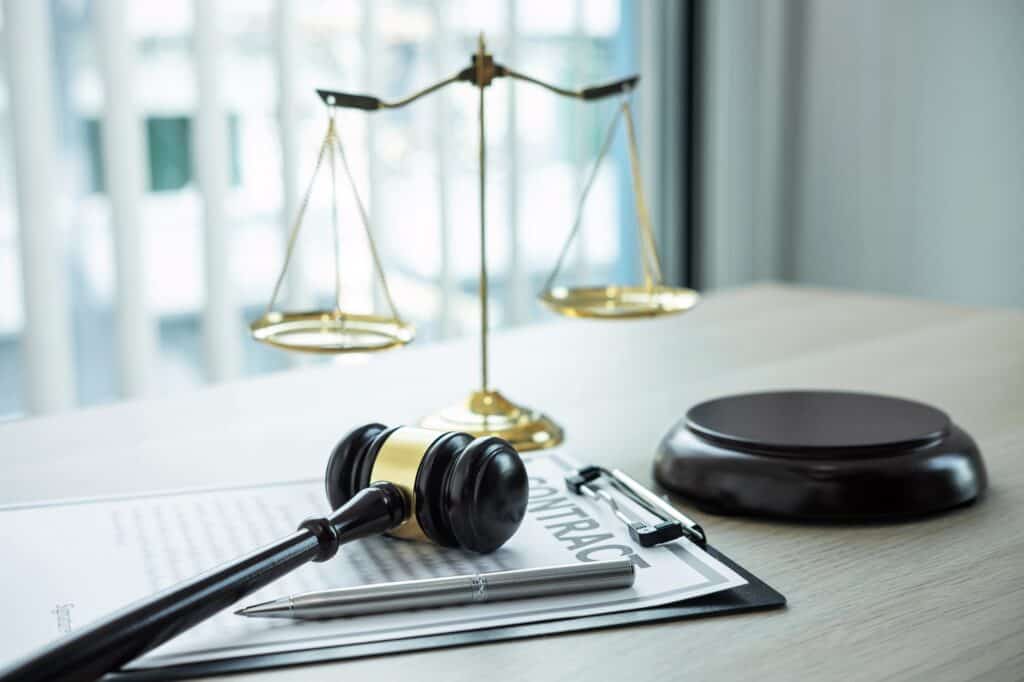 Judge gavel with Justice at law firm in background with legal case document contract