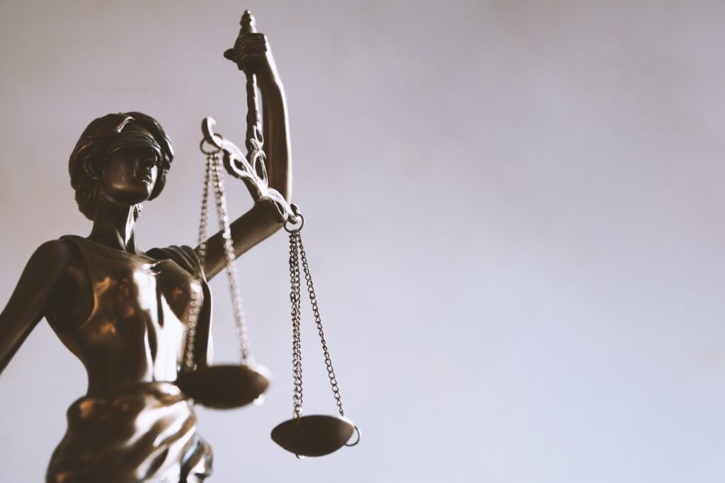 Lady Justice or Justitia statue with blindfold and scales is a symbol for law and legal concepts.