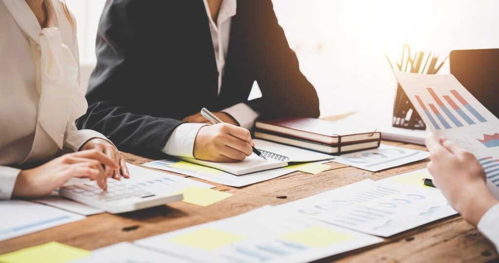 Teamwork with price chart analyzes business people on the table at the conference room.